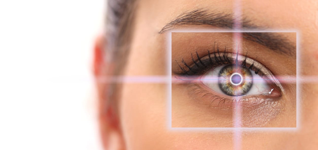 close up of half of a woman's face with computer generated artwork showing a focus of her eye with a solid white background
