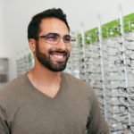 Man Trying On Eyeglasses In Optics Store